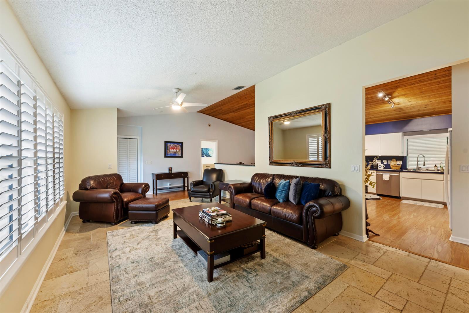 A living room features leather furniture, a coffee table, a large mirror, and tile flooring — 756 Juniper Place, Wellington FL 33414, WELLINGTON, FL