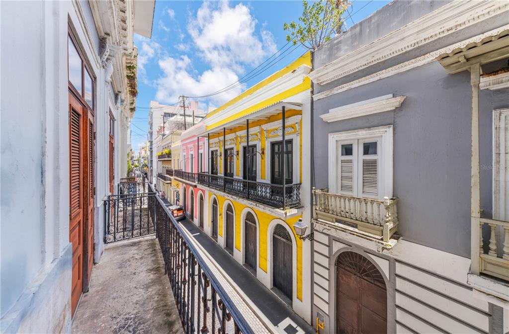A view from a balcony overlooking a narrow street lined with colorful historic colonial buildings — 251/253 TETUAN STREET, SAN JUAN, PR