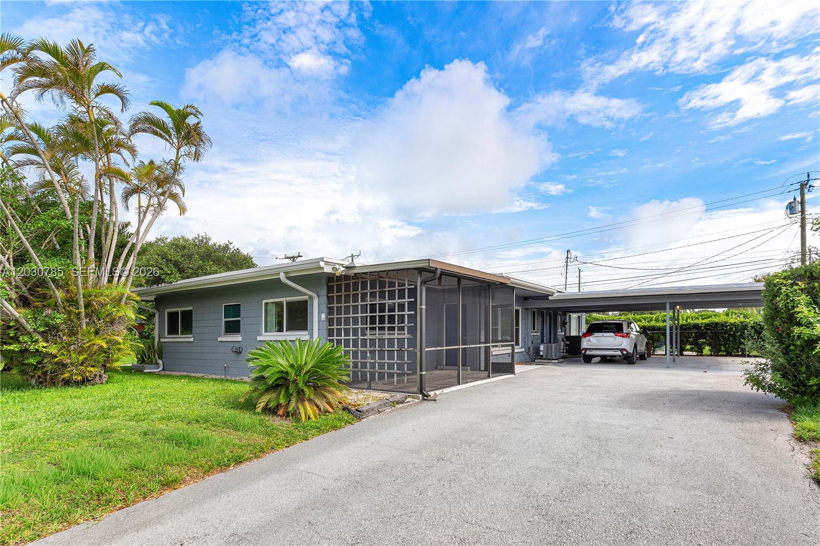 A gray single-story house features a screened-in porch, a paved driveway, and an attached carport — 204 NW 1st St, Boynton Beach FL 33435, BOYNTON BEACH, FL