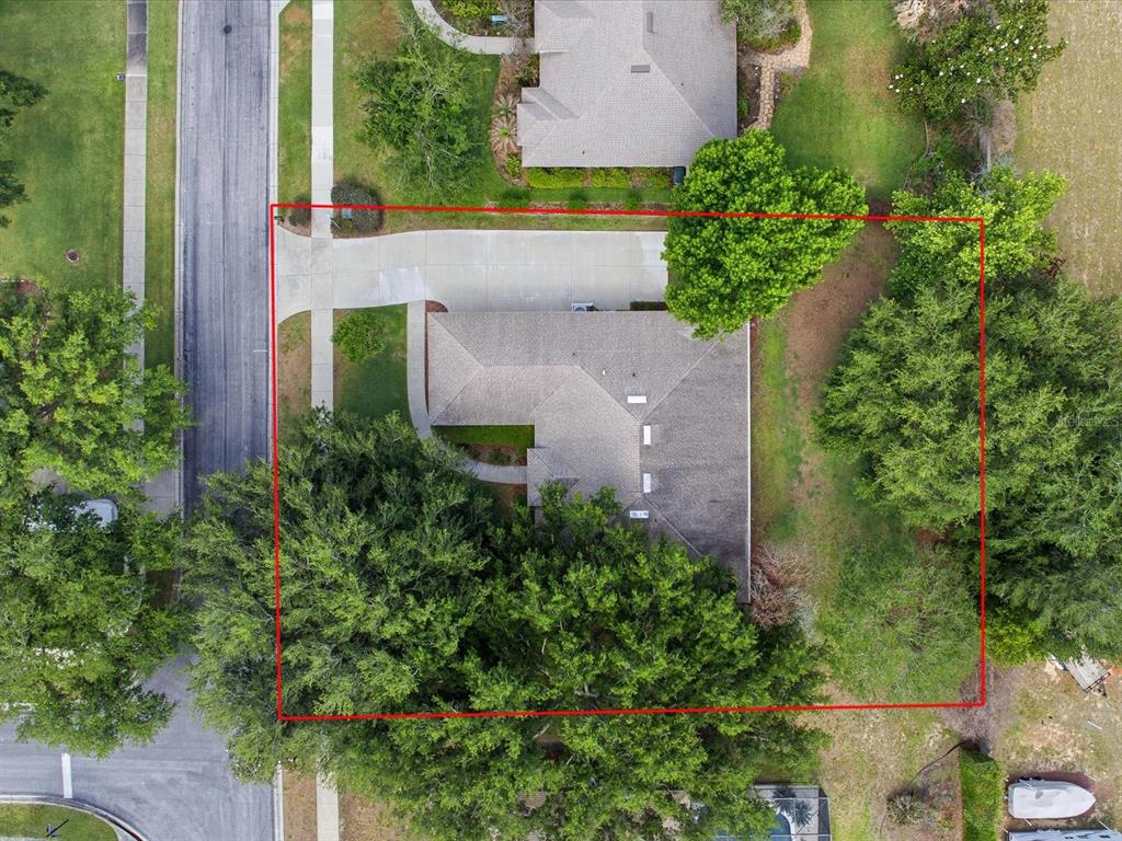 An aerial view shows a house with a driveway and trees within a red boundary — 11906 GRACES WAY, CLERMONT, FL