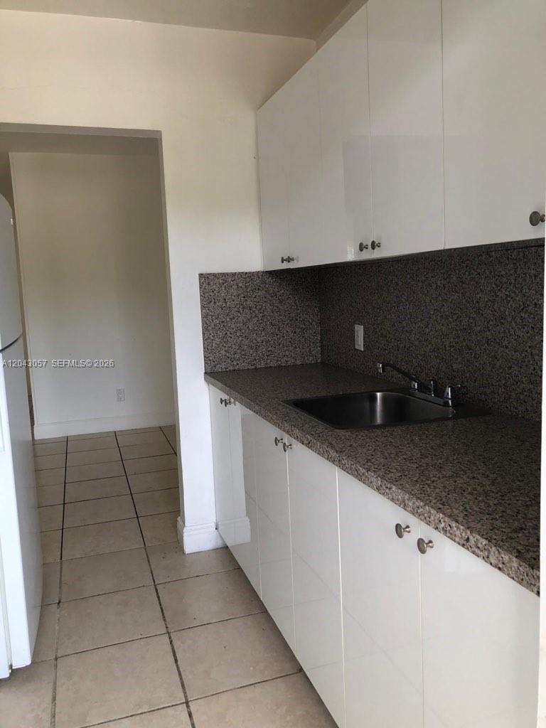 A kitchen features white cabinets, a granite countertop, and a stainless steel sink — 1895 Venice Park Dr # B20, Miami FL 33181, MIAMI, FL