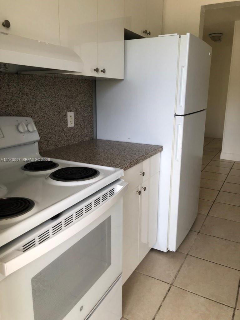 A kitchen features white appliances, white cabinets, and a speckled countertop — 1895 Venice Park Dr # B20, Miami FL 33181, MIAMI, FL