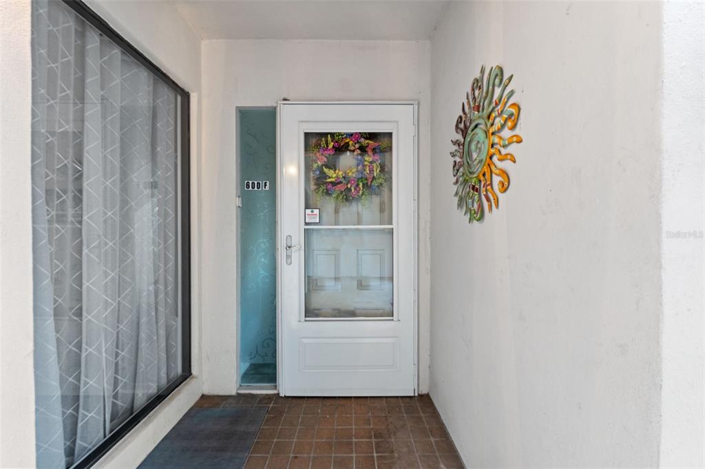 A white front door with a floral wreath and a sun wall decoration — 300 S FLORIDA AVENUE UNIT 600F, TARPON SPRINGS, FL