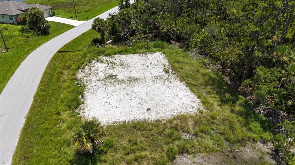 An aerial view of a cleared, sandy residential lot bordered by a road and trees — 109 HAWK DRIVE, ROTONDA WEST, FL