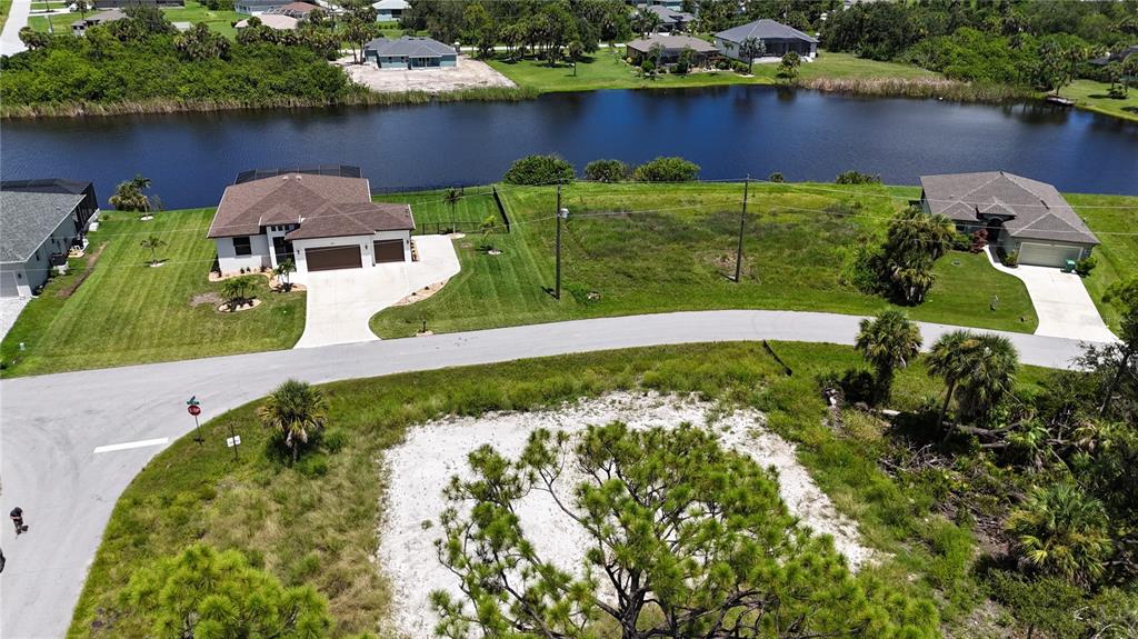 An aerial view shows two houses separated by a vacant lot near a lake — 109 HAWK DRIVE, ROTONDA WEST, FL