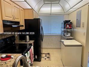 A kitchen features light wood cabinets, black appliances, a chest freezer, and a window — 3571 Inverrary Dr # 408, Lauderhill FL 33319, LAUDERHILL, FL