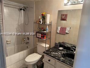 A bathroom features a shower-tub combination, a toilet with a metal shelf, and a vanity — 3571 Inverrary Dr # 408, Lauderhill FL 33319, LAUDERHILL, FL