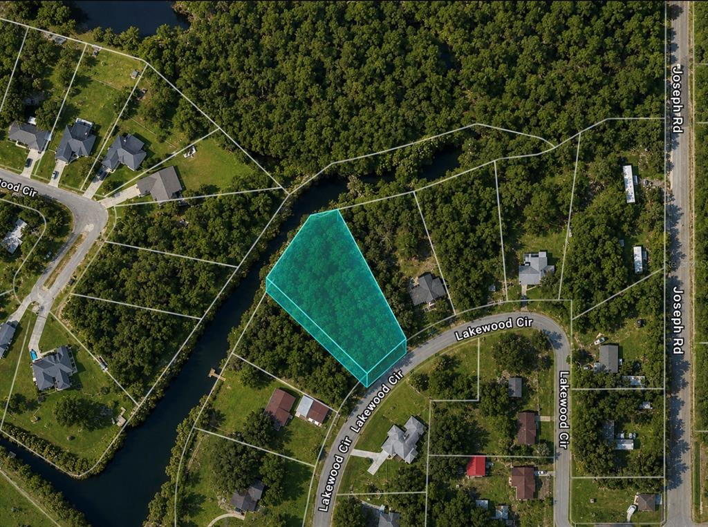 An aerial map shows a highlighted vacant lot along a curved road and a canal — 5527 LAKEWOOD CIRCLE, PANAMA CITY, FL