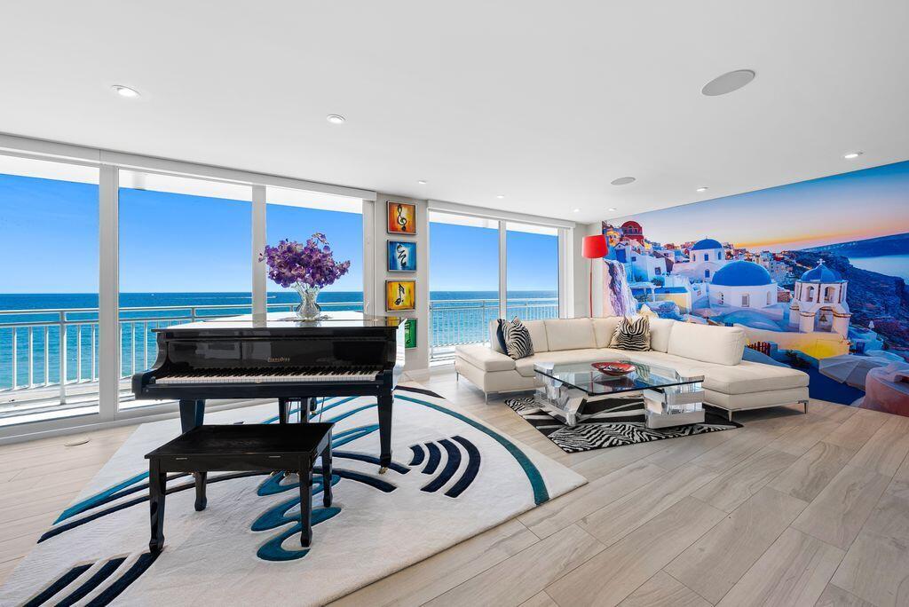 A living room features a grand piano, white sectional sofa, and a mural of Santorini — 2150 N Ocean Boulevard # s, Boca Raton FL 33431, BOCA RATON, FL