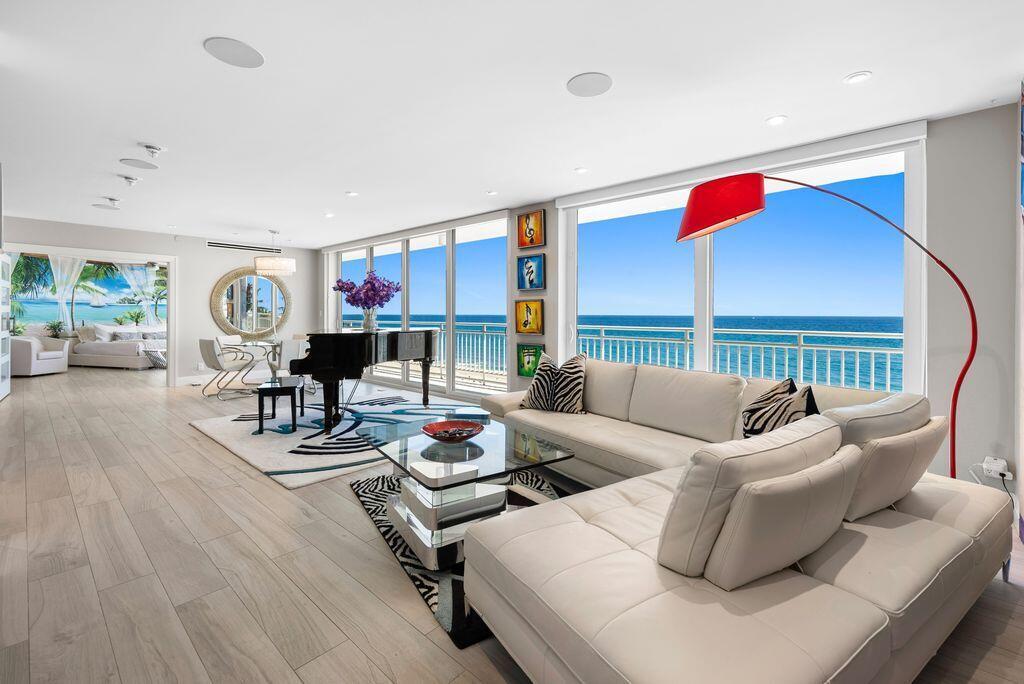 A modern living room with a white sectional, grand piano, and floor-to-ceiling ocean views — 2150 N Ocean Boulevard # s, Boca Raton FL 33431, BOCA RATON, FL