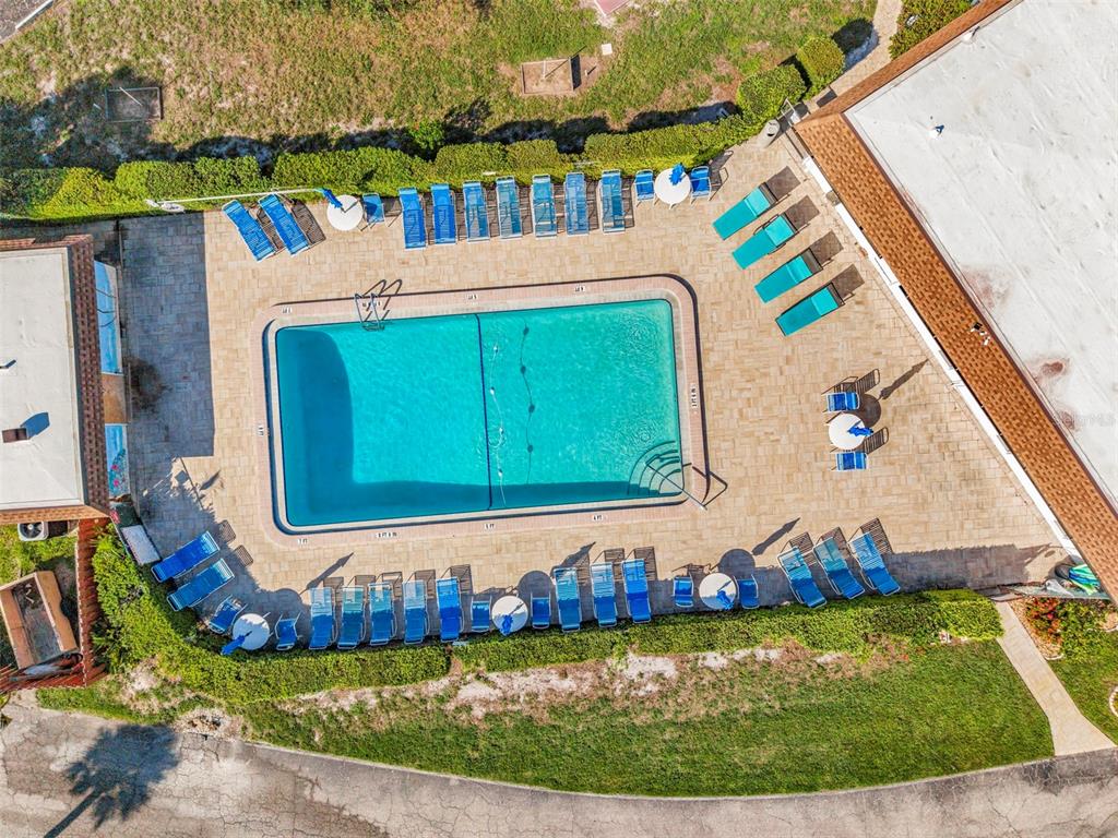 An aerial view shows a rectangular swimming pool surrounded by lounge chairs and patio umbrellas — 8 QUAILS RUN BOULEVARD UNIT 4, ENGLEWOOD, FL