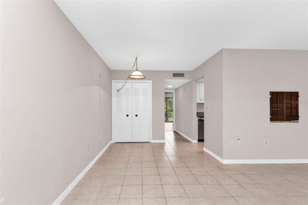 A dining area with tile flooring, a light fixture, and a white closet — 8 QUAILS RUN BOULEVARD UNIT 4, ENGLEWOOD, FL