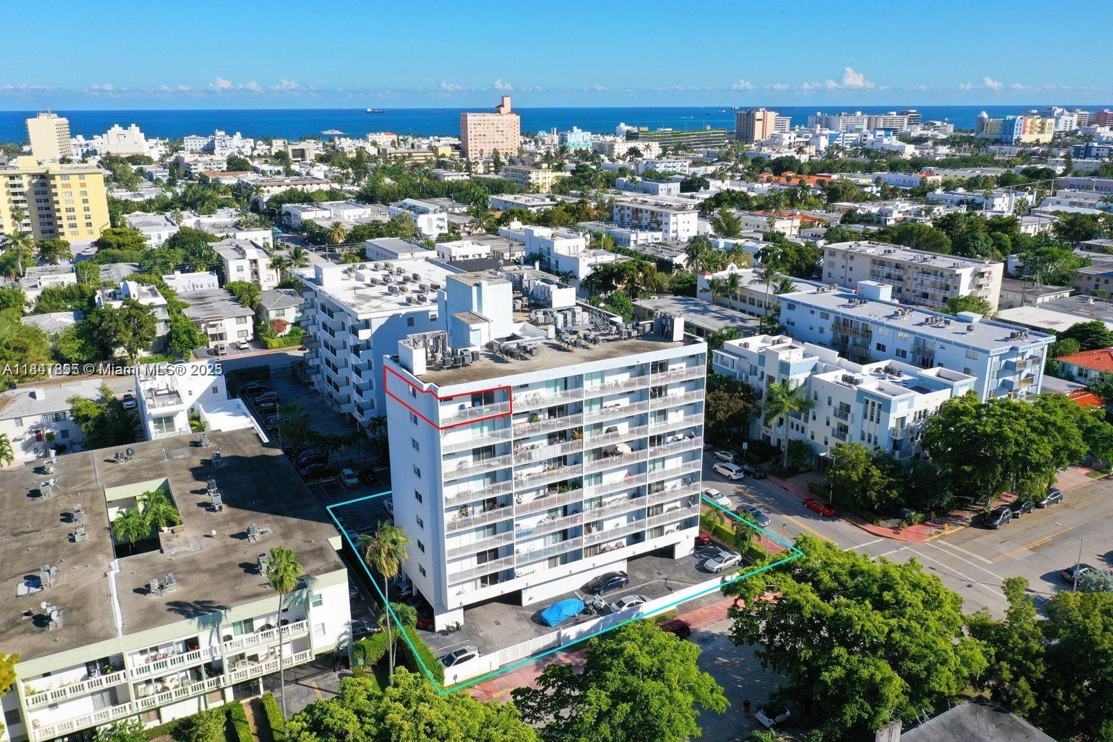 An aerial view shows a multi-story apartment building with balconies and an adjacent parking lot — 1045 10th St # 907, Miami Beach FL 33139, MIAMI BEACH, FL