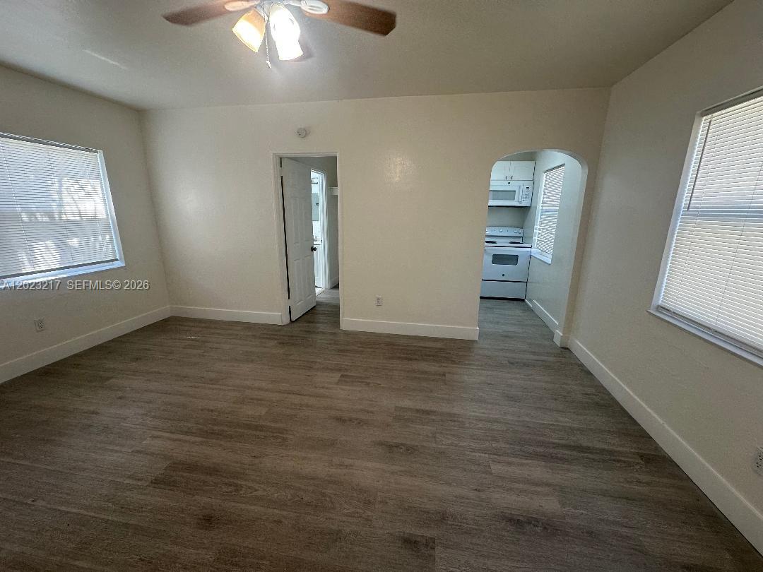 This room features light wood-look flooring, white walls, a ceiling fan, and two doorways — 1956 Lincoln St # 5, Hollywood FL 33020, HOLLYWOOD, FL