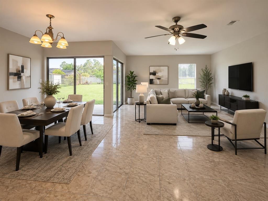 An open-concept living and dining area features tile flooring, a ceiling fan, and sliding doors — 707 WEDGE LANE, POINCIANA, FL