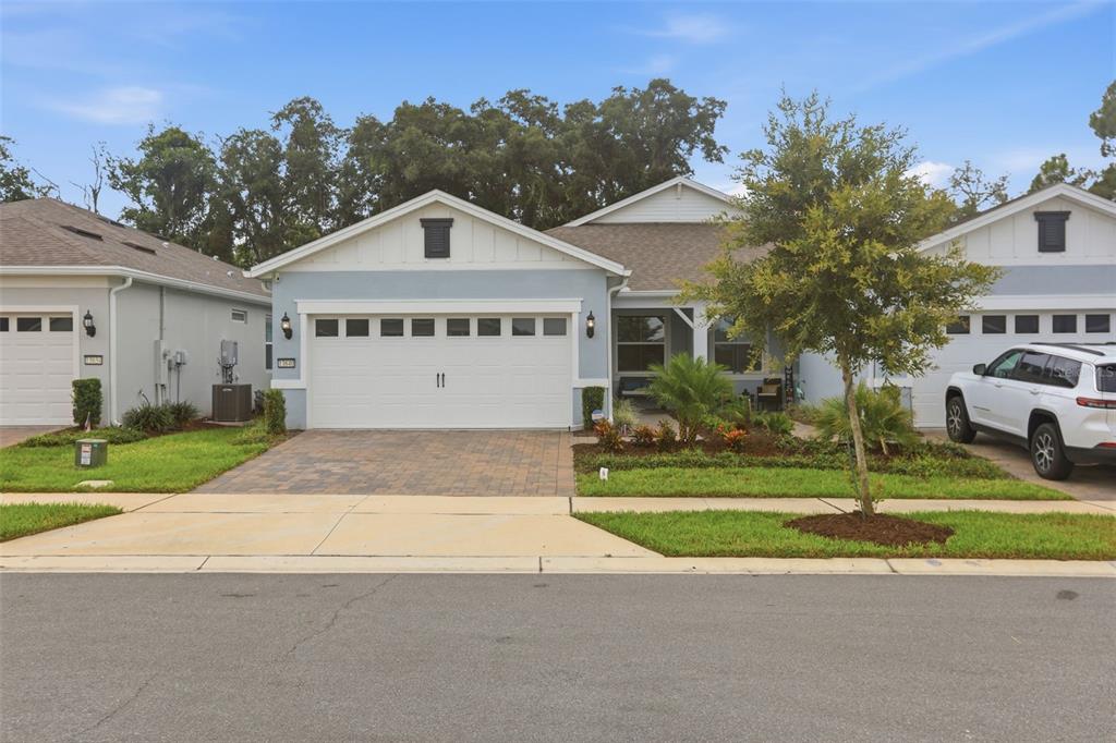 A light blue single-story house with a two-car garage and a paved driveway — 13640 SPLASHING ISLA DRIVE, WINTER GARDEN, FL