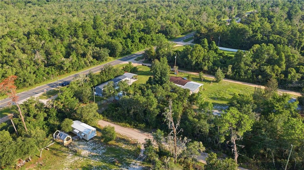 An aerial view shows two houses and a small trailer on a wooded rural lot — TBD NE 235TH STREET, FORT MC COY, FL