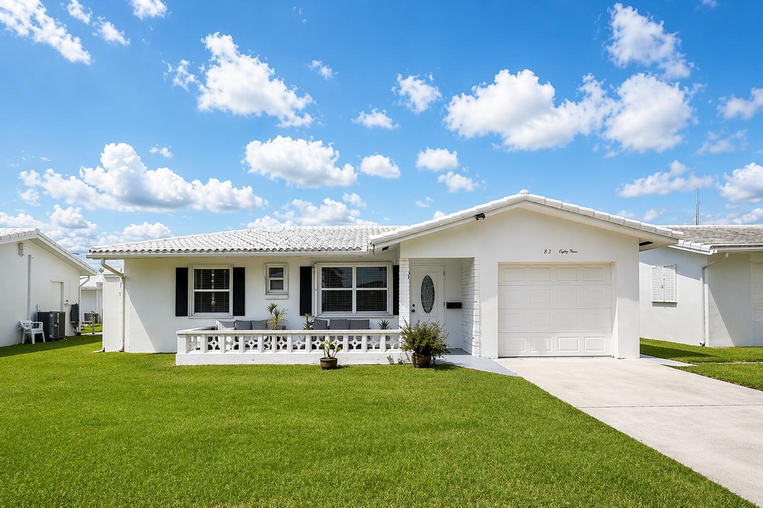 A single-story white house with a tiled roof, a front patio, and a concrete driveway — 517 SW 18th Street, Boynton Beach FL 33426, BOYNTON BEACH, FL