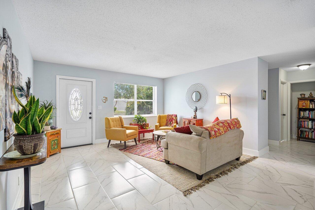 A living room features light-colored tile floors, two yellow armchairs, and a beige sofa — 517 SW 18th Street, Boynton Beach FL 33426, BOYNTON BEACH, FL