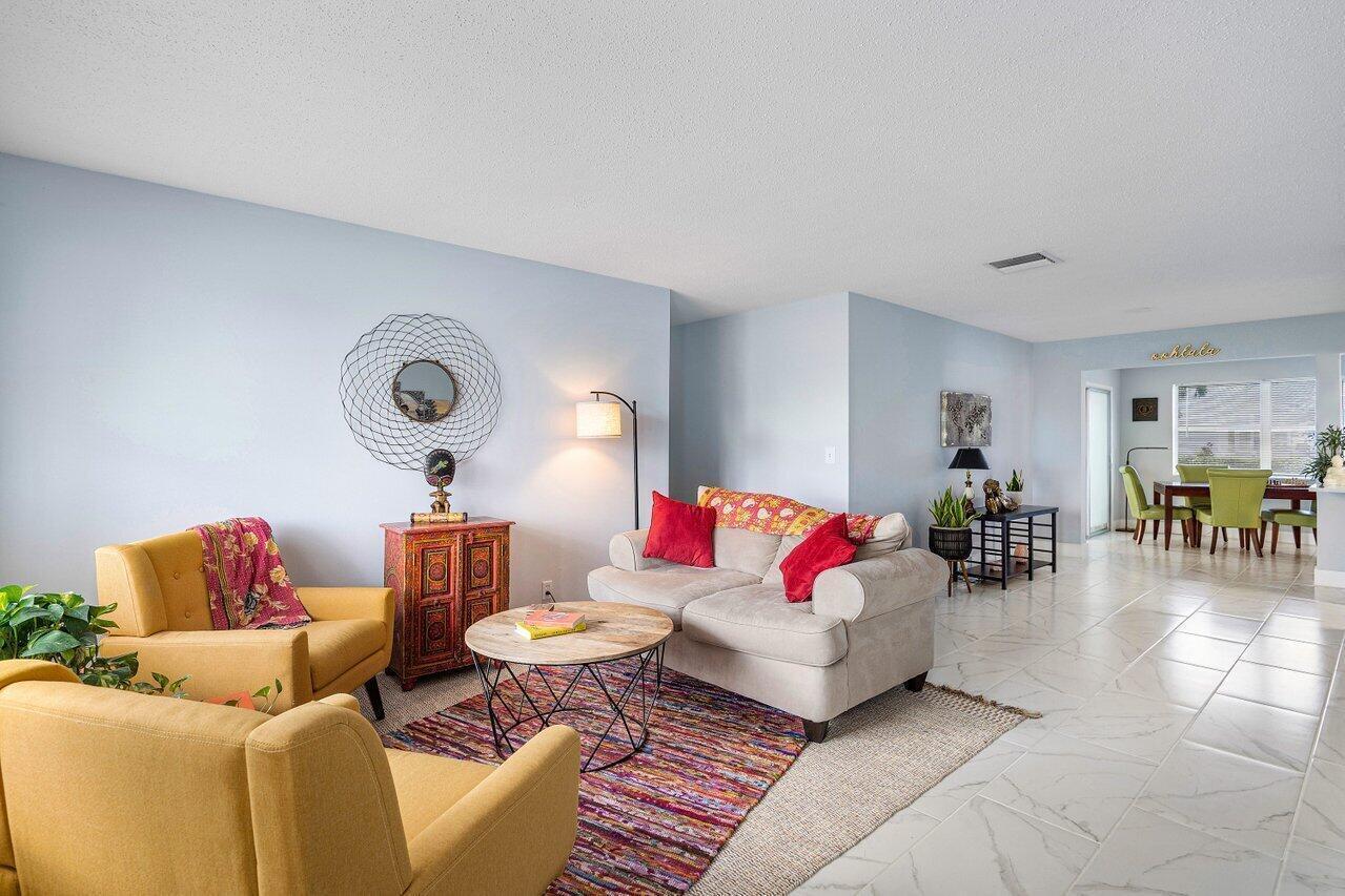 A living room with yellow armchairs, a beige sofa, and a round wooden coffee table — 517 SW 18th Street, Boynton Beach FL 33426, BOYNTON BEACH, FL