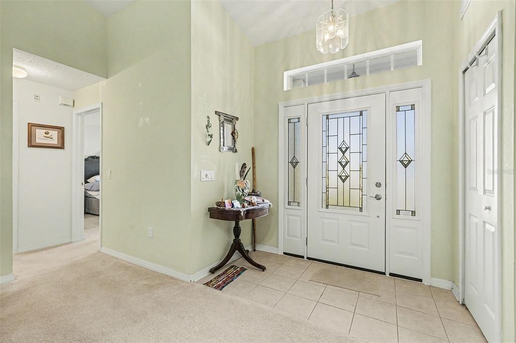 A single-story house with a beige exterior, a two-car garage, and a manicured front lawn — 11220 HOLLANDER AVENUE, HUDSON, FL
