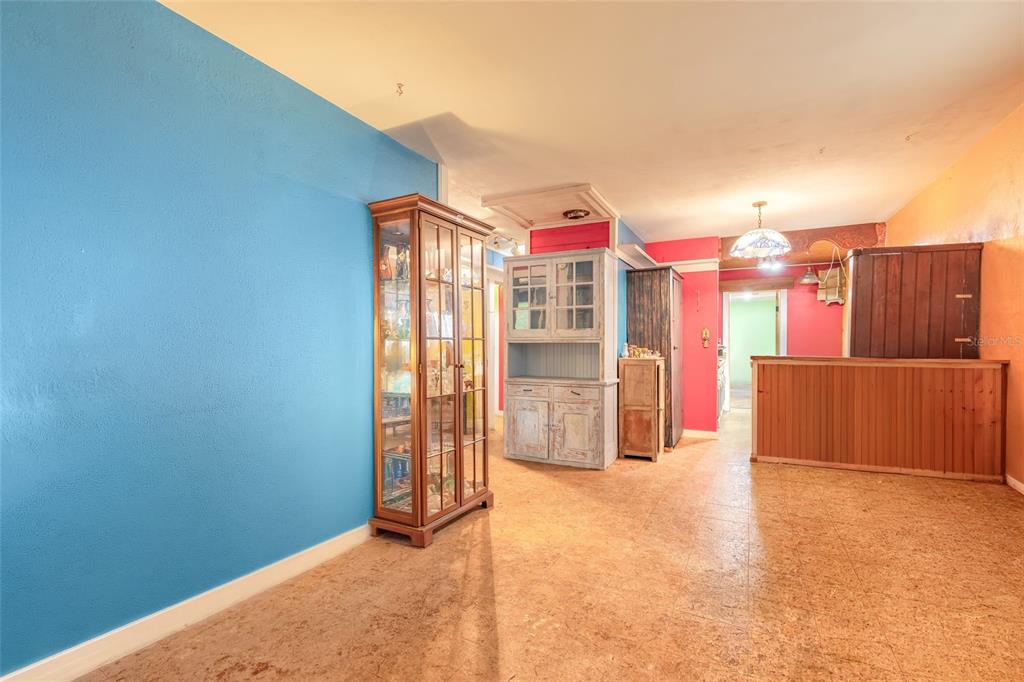A room with blue walls, a glass display cabinet, a hutch, and tiled flooring — 1219 LEON LANE, DAYTONA BEACH, FL