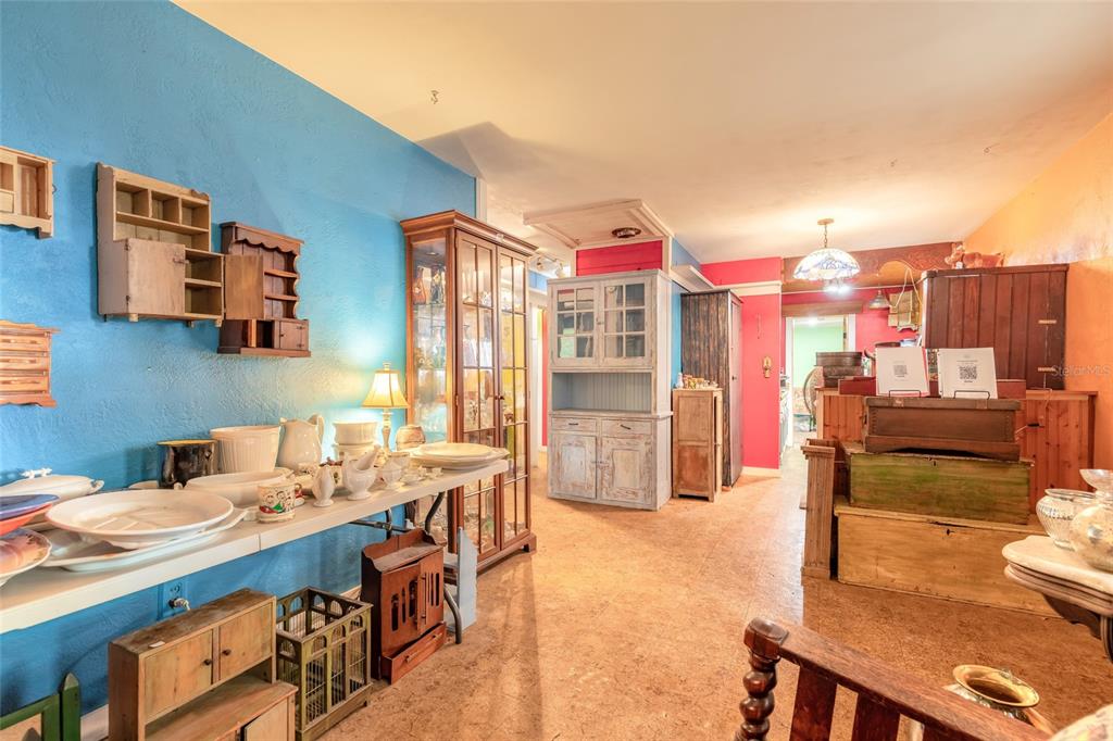A room with blue walls, a cork floor, and various wooden cabinets and display tables — 1219 LEON LANE, DAYTONA BEACH, FL
