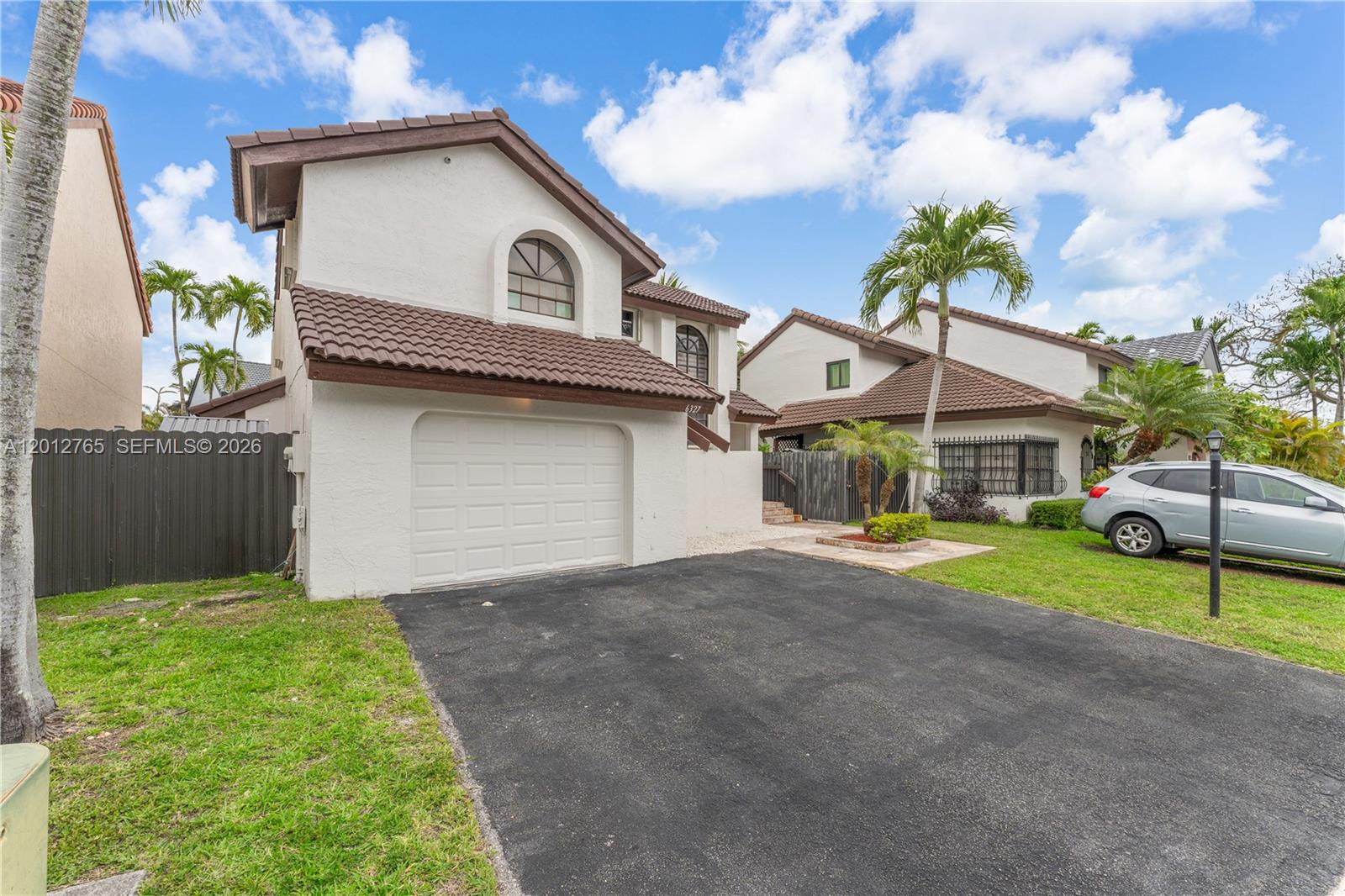 A two-story house with a white stucco exterior, brown tile roof, and a single-car garage — 6327 SW 127th Pl, Miami FL 33183, MIAMI, FL