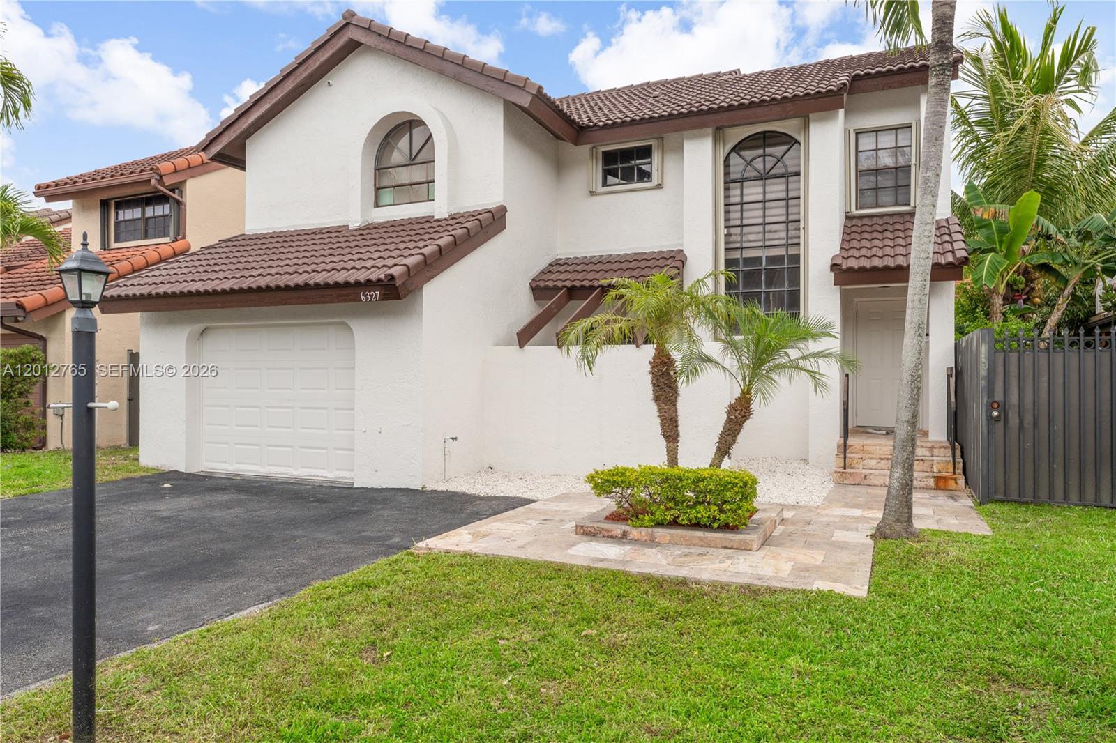 A two-story house features a white stucco exterior, brown tile roof, and a single-car garage — 6327 SW 127th Pl, Miami FL 33183, MIAMI, FL