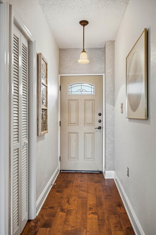A hallway features wood flooring, a light-colored door with a window, and a pendant light — 401 E ROBINSON STREET UNIT 304, ORLANDO, FL
