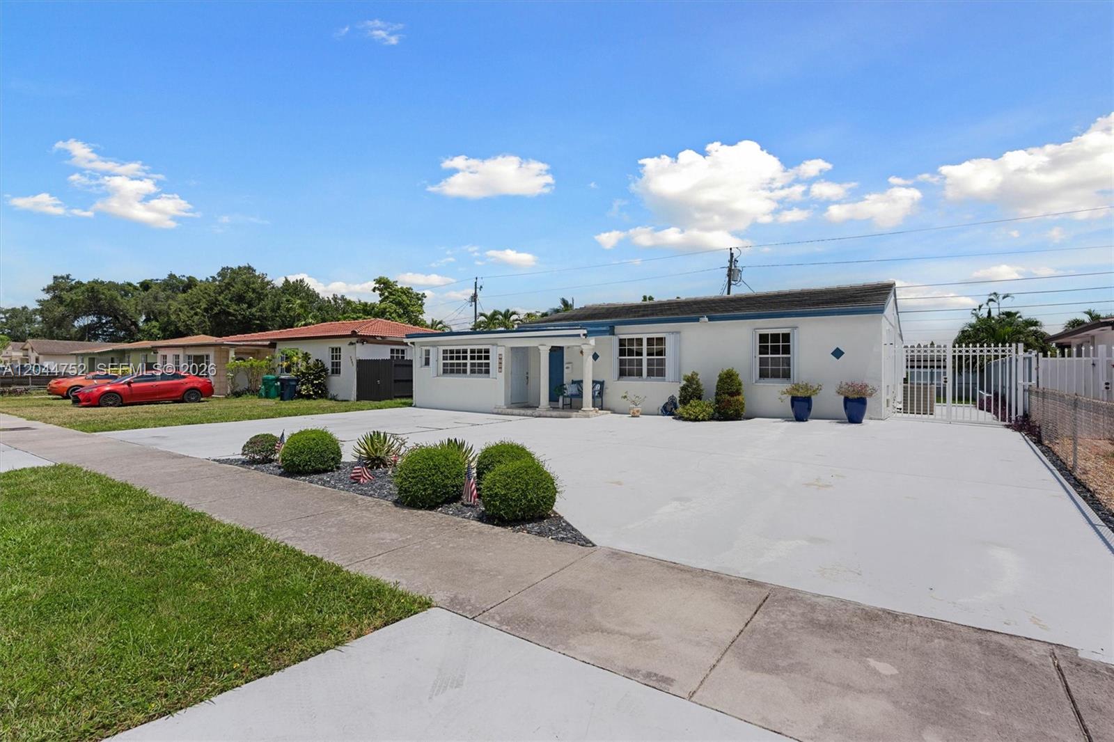 A single-story white house features a large concrete driveway and a small front garden — 7281 SW 13th Ter, Miami FL 33144, MIAMI, FL