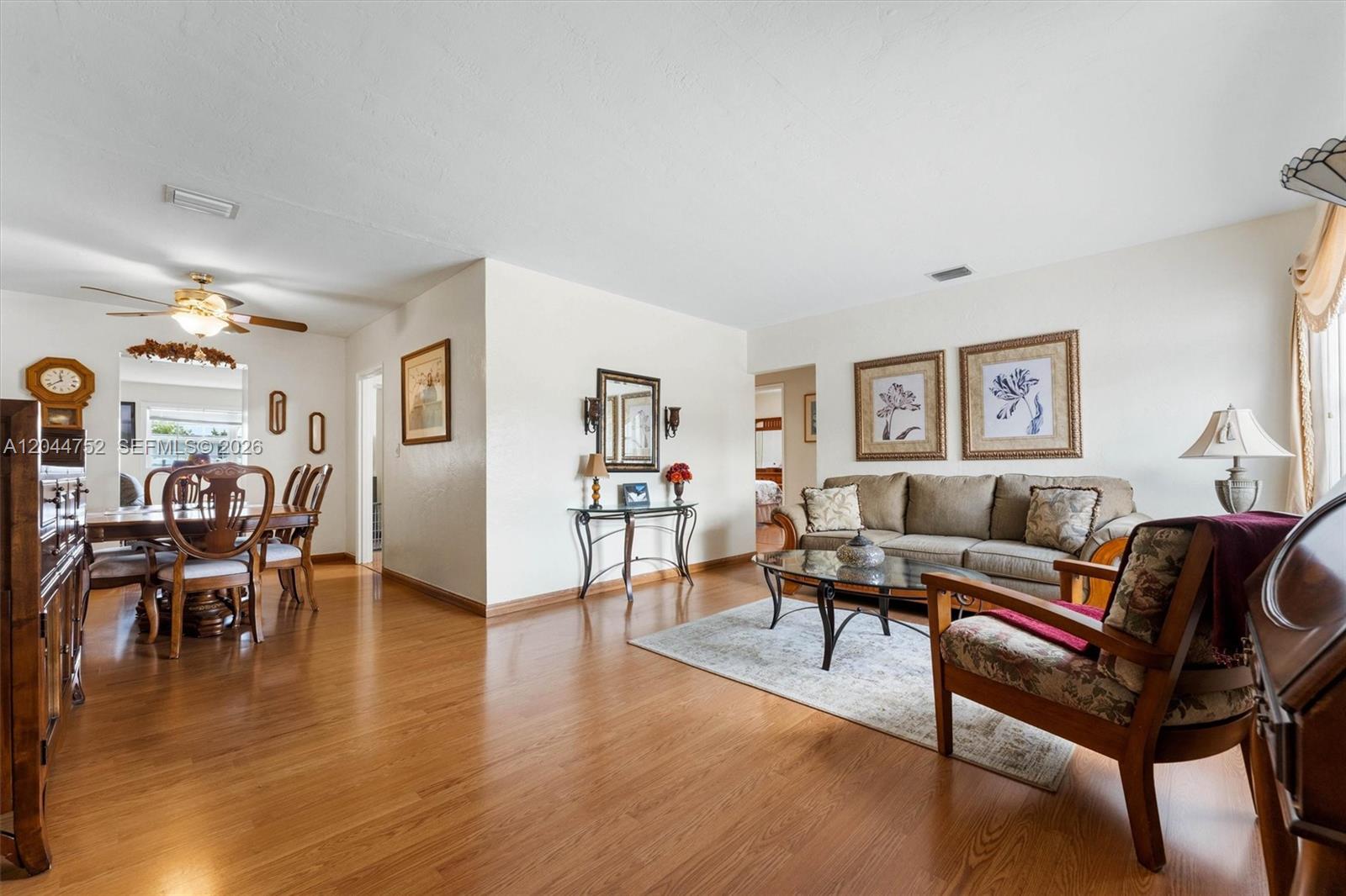 A living room and dining area with hardwood floors, a sofa, and a glass coffee table — 7281 SW 13th Ter, Miami FL 33144, MIAMI, FL
