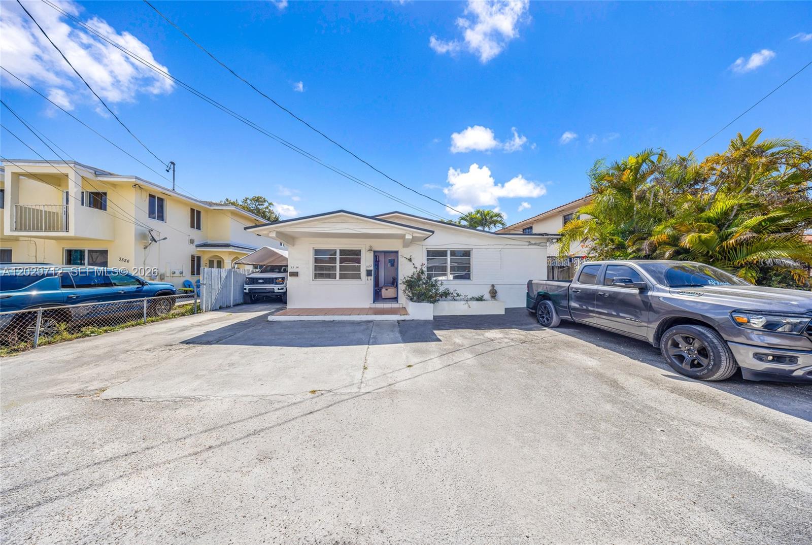 A single-story house with a concrete driveway and two parked pickup trucks — 3532 NW 4th Ter, Miami FL 33125, MIAMI, FL