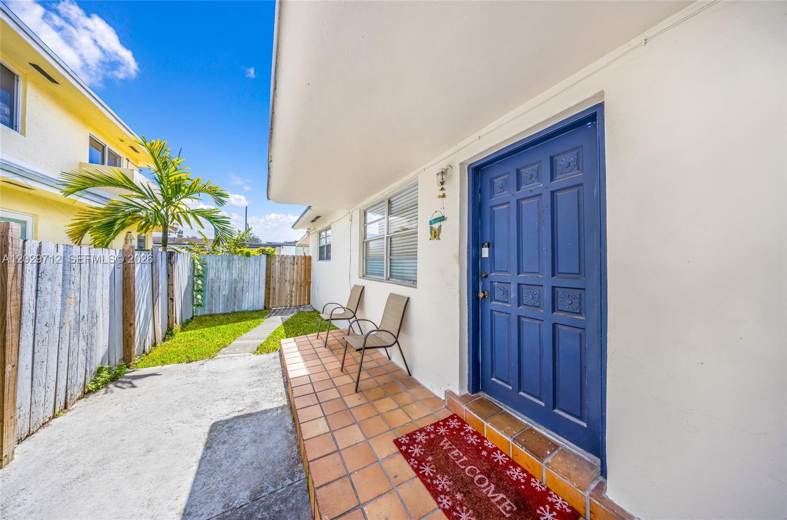 A blue front door opens onto a tiled porch with two chairs and a mat — 3532 NW 4th Ter, Miami FL 33125, MIAMI, FL