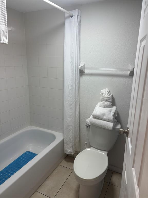 A modern lobby features three armchairs, marble-look tile flooring, and large windows overlooking a street — 9980 GULF BOULEVARD UNIT 317, ST PETERSBURG, FL