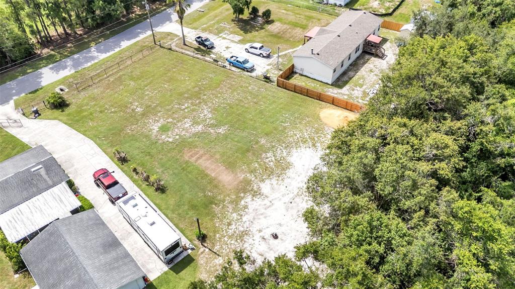 An aerial view shows a large, grassy lot with a house, vehicles, and a trailer — 3632 LAUREL CREST DRIVE, MULBERRY, FL