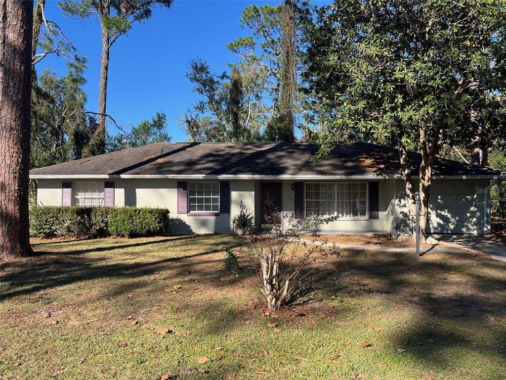 A single-story house with a light-colored exterior, a dark roof, and a front yard — 5701 SE 2ND PLACE, OCALA, FL