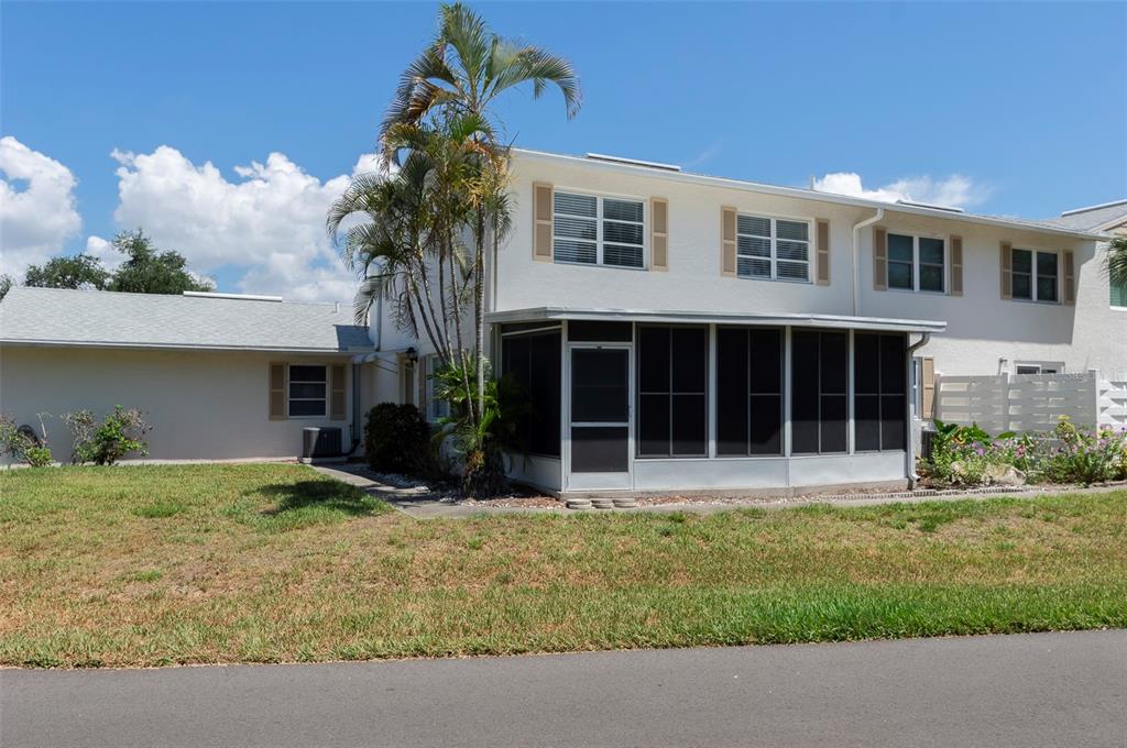 A two-story townhouse with a screened-in porch, palm tree, and light-colored exterior siding — 3281 38TH WAY S UNIT C, ST PETERSBURG, FL