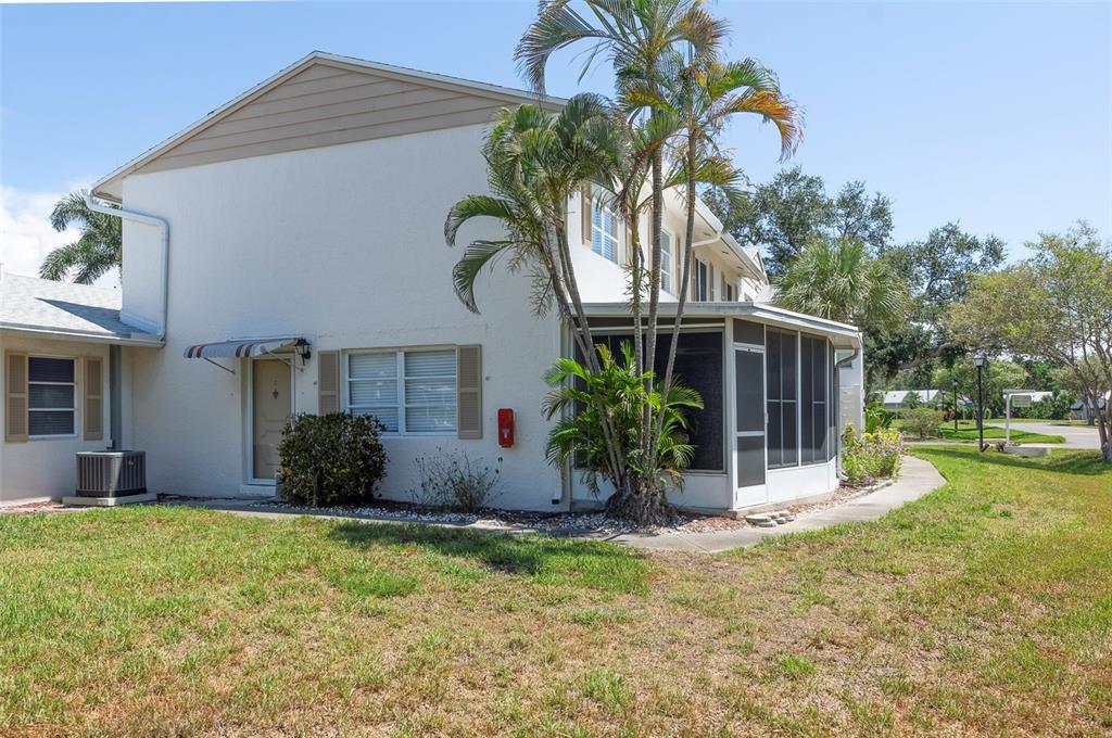 A two-story residential building features a screened-in porch, palm trees, and a grassy yard — 3281 38TH WAY S UNIT C, ST PETERSBURG, FL