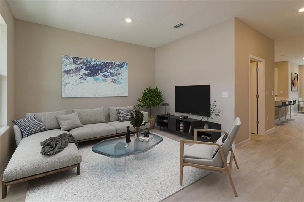 This is a virtually staged living room featuring a sectional sofa, coffee table, and television — 13295 PEACEFUL MELODY DRIVE, WINTER GARDEN, FL