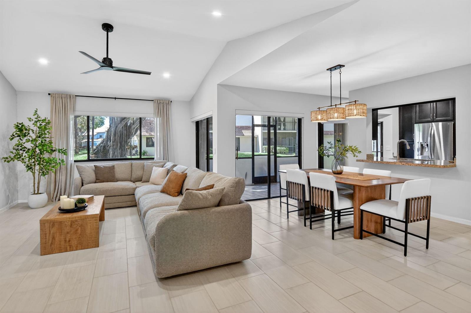 A living and dining area features light tile floors, a sectional sofa, and wood furniture — 5530 Coach House Circle # A, Boca Raton FL 33486, BOCA RATON, FL