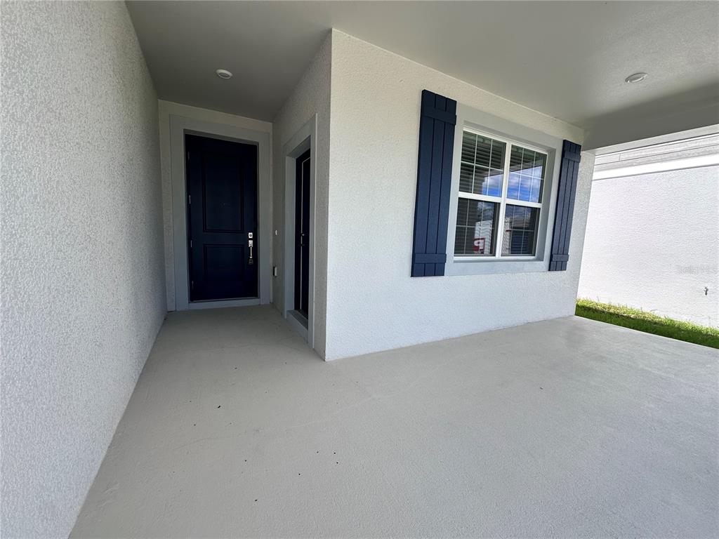 A single-story house exterior features a white garage, a covered porch, and a paved driveway — 5524 FIONA LANE, ST CLOUD, FL