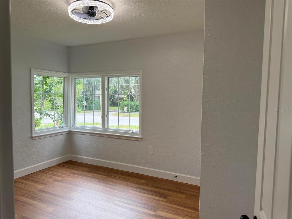 A tan, single-story brick house with a screened-in porch and a concrete driveway — 1200 SUNSHINE AVENUE, LEESBURG, FL