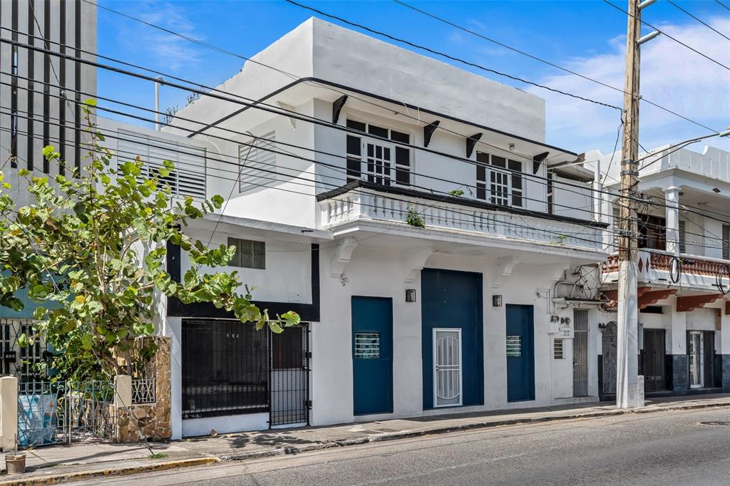 A two-story white building with a balcony and dark blue doors on a street — #159 CALLE VILLA, PONCE, PR