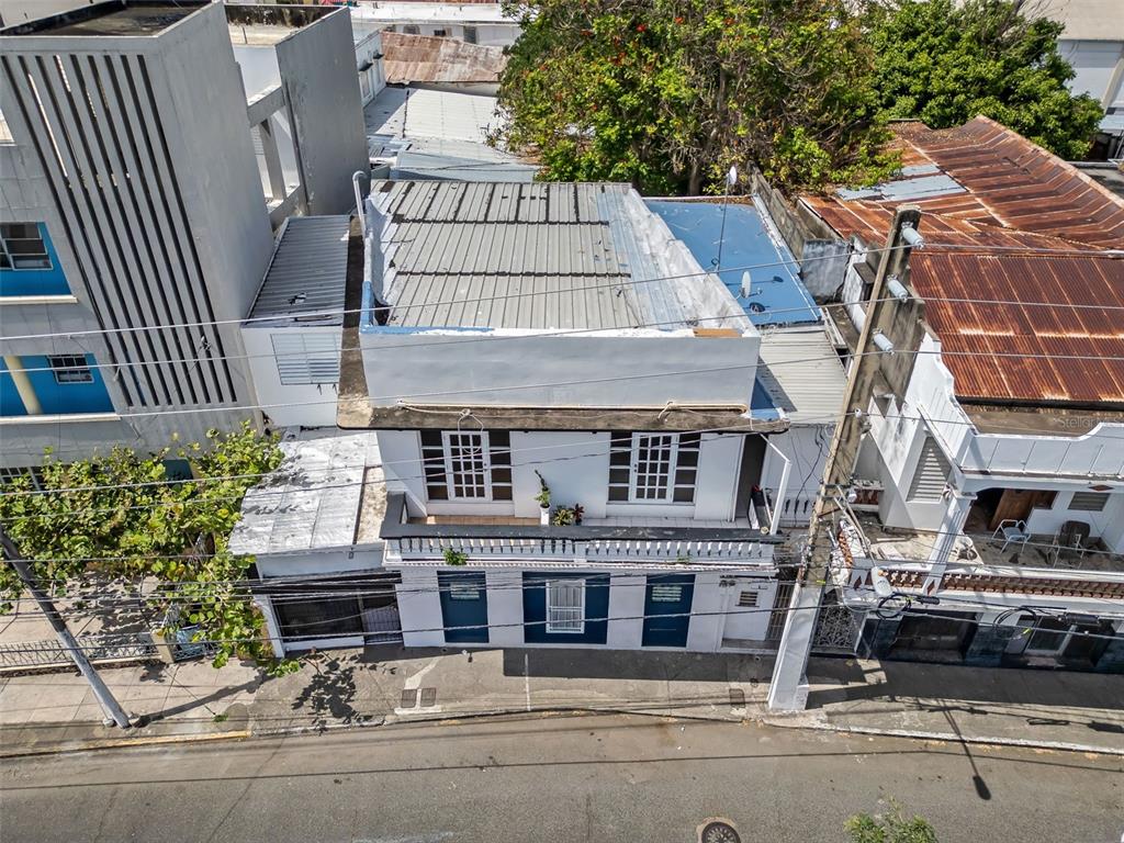 An aerial view of a two-story white building with a metal roof and balcony — #159 CALLE VILLA, PONCE, PR