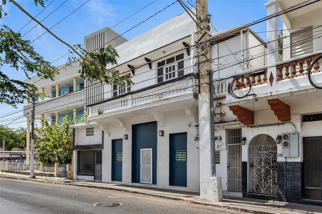 A street-level view of a white two-story building with blue accents and a balcony — #159 CALLE VILLA, PONCE, PR