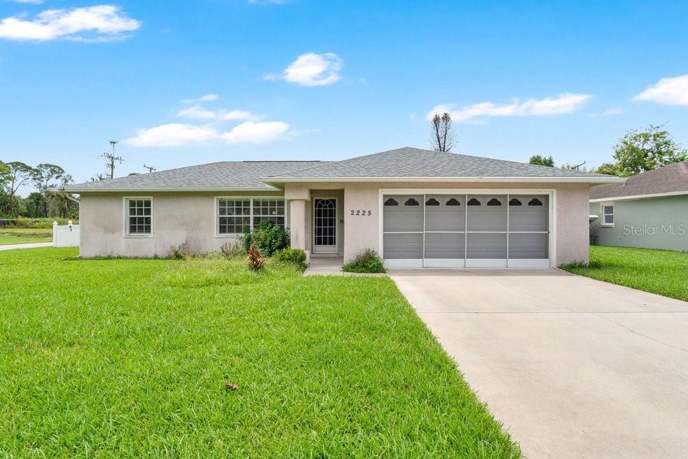 A single-story house with a gray roof, light-colored stucco exterior, and a two-car garage — 2225 MARYLAND AVENUE, TITUSVILLE, FL