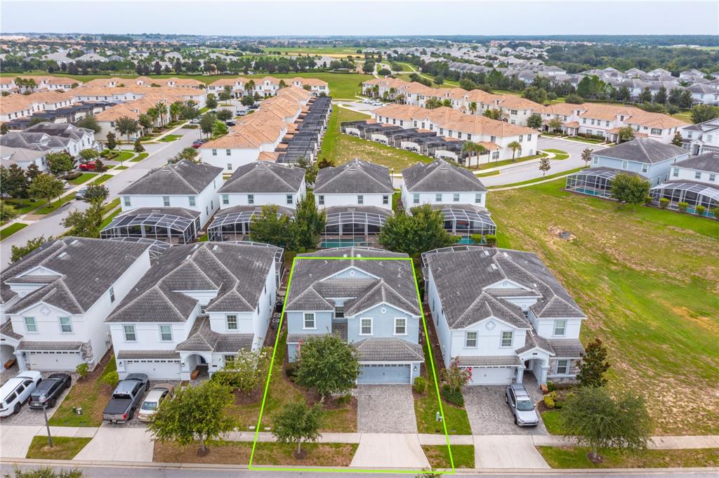 An aerial view shows a light blue two-story house with a paved driveway and yard — 1673 MOON VALLEY DRIVE, DAVENPORT, FL