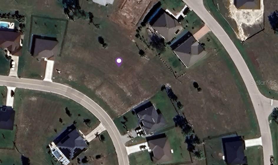 This aerial view shows a vacant residential lot marked with a purple pin — 25418 DOREDO DRIVE, PUNTA GORDA, FL