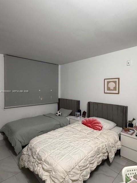 A bedroom features two twin beds with gray and white bedding against a white wall — 4540 NW 107th Ave # 11, Doral FL 33178, DORAL, FL